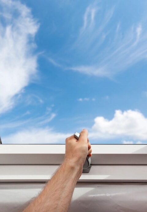 Image of hand opening up skylight window